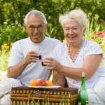 hearing elderly couple enjoying a picnic