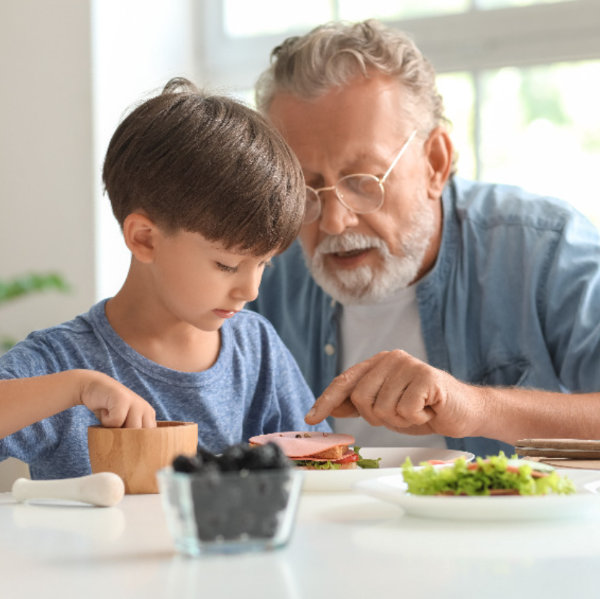 Young boy making sandwich with grandfather